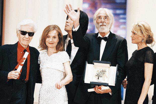 Ο Μίκαελ Χάνεκε κρατά στα χέρια του το Χρυσό Φοίνικα, ενώ ποζάρει δίπλα στην παλιά του γνώριμη από τη  Δασκάλα του Πιάνου  και πρόεδρο της επιτροπής των Καννών, Ιζαμπέλ Ιπέρ και τον Αλέν Ρενέ, ο οποίο